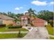 Charming single-Gathering home showcasing a well-maintained lawn, mature palm trees, and a two-car garage at 18005 Palm Breeze Dr, Tampa, FL 33647