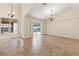 Spacious living room with tile flooring, chandelier, and large sliding glass doors overlooking the pool area at 18005 Palm Breeze Dr, Tampa, FL 33647