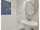 All-white bathroom with blue tile accents featuring a new sink and vanity at 2049 Broadway, Clearwater, FL 33755