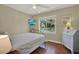 Cozy bedroom with hardwood floors, a large window overlooking the yard, and neutral decor at 2049 Broadway, Clearwater, FL 33755