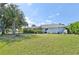 Back yard featuring well-maintained green grass, lush landscaping, and a screened-in patio and pool at 26180 Deep Creek Blvd, Punta Gorda, FL 33983