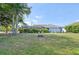 Sprawling back yard featuring well-maintained green grass, lush landscaping, and a screened-in patio and pool at 26180 Deep Creek Blvd, Punta Gorda, FL 33983
