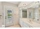 Bathroom features white tile, a large mirror, and a door to the pool area at 26180 Deep Creek Blvd, Punta Gorda, FL 33983