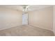 Carpeted bedroom featuring a ceiling fan, an open closet door, baseboard trim, and white walls at 26180 Deep Creek Blvd, Punta Gorda, FL 33983