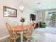 Comfortable dining area featuring a classic wooden table, a painting, a view of the living room, and natural light at 2882 Suncoast Plains Dr, Odessa, FL 33556