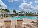 Community pool features clear water, palm trees, lounge chairs, and a covered pavilion for residents' enjoyment at 2882 Suncoast Plains Dr, Odessa, FL 33556