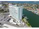 Aerial view showing a condo building near water with docks and a parking lot at 31 Island Way # 505, Clearwater Beach, FL 33767