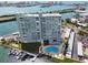 Aerial view showcasing waterfront condo building, pool, dock, and cityscape views at 31 Island Way # 505, Clearwater Beach, FL 33767