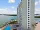 Exterior view of a tall condo building showcasing pool and boat docks at 31 Island Way # 505, Clearwater Beach, FL 33767
