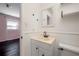 Bright bathroom features a cream vanity, toilet, and a wall mirror with a decorative shelf above at 3212 W Arch St, Tampa, FL 33607