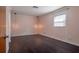 A light-filled bedroom offers hardwood floors, two hanging pendant lights, and a window with stylish white trim at 3212 W Arch St, Tampa, FL 33607
