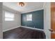 Charming bedroom with hardwood floors, textured accent wall, and bright windows with white wood trim at 3212 W Arch St, Tampa, FL 33607