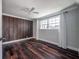 Inviting bedroom with rich wood paneled accent wall, wood floor, and large bright window at 3212 W Arch St, Tampa, FL 33607