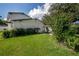 Exterior side and backyard view of home with ample green foliage at 3212 W Arch St, Tampa, FL 33607