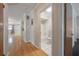 Hallway view, with hardwood floors, leading to a bathroom featuring tile floors and a combined shower/tub at 3212 W Arch St, Tampa, FL 33607