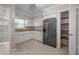 Bright kitchen features white cabinets, a stainless steel refrigerator, and a pantry at 3212 W Arch St, Tampa, FL 33607