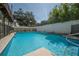 Sparkling blue tiled pool with sun ledge offers a refreshing backyard oasis at 3212 W Arch St, Tampa, FL 33607