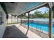Covered patio with string lights overlooking a refreshing pool with protective fence at 3212 W Arch St, Tampa, FL 33607