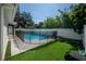 Backyard pool area features an in-ground pool with black safety fence and ample artificial grass lawn space at 3212 W Arch St, Tampa, FL 33607