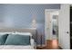 Tastefully decorated bedroom with blue patterned wallpaper and an ensuite bathroom at 3505 W Kensington Ave, Tampa, FL 33629