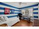Cozy bedroom with blue and white striped walls, featuring a workspace and natural light at 3505 W Kensington Ave, Tampa, FL 33629
