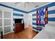 Bright bedroom with blue striped walls, ceiling fan, hardwood floors and football scarves at 3505 W Kensington Ave, Tampa, FL 33629