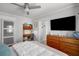 Bright bedroom featuring a wooden desk, a ceiling fan, and a large window at 3505 W Kensington Ave, Tampa, FL 33629