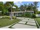 Inviting single-story home with a modern driveway, lush landscaping, and palm trees at 3505 W Kensington Ave, Tampa, FL 33629