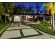 Charming home exterior features a modern driveway design and lush landscaping, enhancing curb appeal at 3505 W Kensington Ave, Tampa, FL 33629