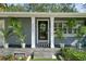 Close up of front door with porch plants, transom windows, and manicured front yard landscaping at 3505 W Kensington Ave, Tampa, FL 33629
