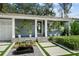 Inviting front porch with decorative plants and a modern water feature, adding charm and curb appeal at 3505 W Kensington Ave, Tampa, FL 33629