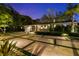 Beautifully landscaped front yard with a unique modern driveway and mature trees at twilight at 3505 W Kensington Ave, Tampa, FL 33629