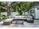 Relax outdoors in a private patio oasis featuring a large outdoor sectional sofa and a charming fire pit table at 3505 W Kensington Ave, Tampa, FL 33629