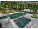 Backyard oasis featuring a stone-paved pool with a spa surrounded by lush, tropical landscaping at 3505 W Kensington Ave, Tampa, FL 33629