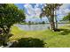 Serene backyard view overlooking a calm lake, framed by lush greenery and trees at 3890 Mainlands N Blvd, Pinellas Park, FL 33782