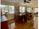 Bright dining room featuring a large wooden table, windows, hardwood floors and a ceiling fan at 3890 Mainlands N Blvd, Pinellas Park, FL 33782