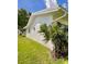 The side of a well-maintained white home, showcasing healthy landscaping and lush green lawn at 3890 Mainlands N Blvd, Pinellas Park, FL 33782