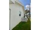 Side view of a white home, showing decorative lattice detail, lush lawn, and a view of the serene waterway at 3890 Mainlands N Blvd, Pinellas Park, FL 33782