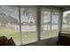 A light-filled sunroom with large windows offering serene views of a lush lawn and tranquil lake at 3890 Mainlands N Blvd, Pinellas Park, FL 33782