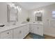 Bright bathroom featuring dual sinks, quartz countertops, framed mirrors, and wood-look tile flooring at 3910 Doral Dr, Tampa, FL 33634