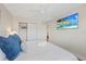 Well-lit bedroom featuring a bed with decorative pillows, closet with sliding doors, and a mounted television at 3910 Doral Dr, Tampa, FL 33634