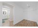 A well-lit, wood-floored closet with shelving, located adjacent to the bathroom at 3910 Doral Dr, Tampa, FL 33634