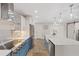 Spacious open-concept kitchen with blue accents, a large island, stainless steel appliances, and modern lighting at 3910 Doral Dr, Tampa, FL 33634