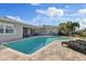 Backyard pool with brick pavers, lounge chairs, and covered patio seating at 3910 Doral Dr, Tampa, FL 33634