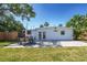 A brick patio with an outdoor dining table sits off the rear of the home with grassy lawn at 4001 W North A St, Tampa, FL 33609