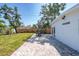 Backyard brick patio with an outdoor dining table and lush green lawn extending to a wooden fence at 4001 W North A St, Tampa, FL 33609