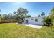 An outdoor dining set on brick patio with grassy lawn, surrounded by a wooden fence and mature trees at 4001 W North A St, Tampa, FL 33609