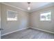 A light-filled bedroom with gray wood floors, complemented by two windows and a decorative ceiling light fixture at 4001 W North A St, Tampa, FL 33609