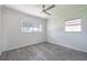 Bright bedroom with gray wood floors, two windows, and a ceiling fan, offering comfort and ample natural light at 4001 W North A St, Tampa, FL 33609