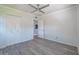 A light bedroom with gray wood floors, a ceiling fan, a closet, and a connecting door to another room at 4001 W North A St, Tampa, FL 33609